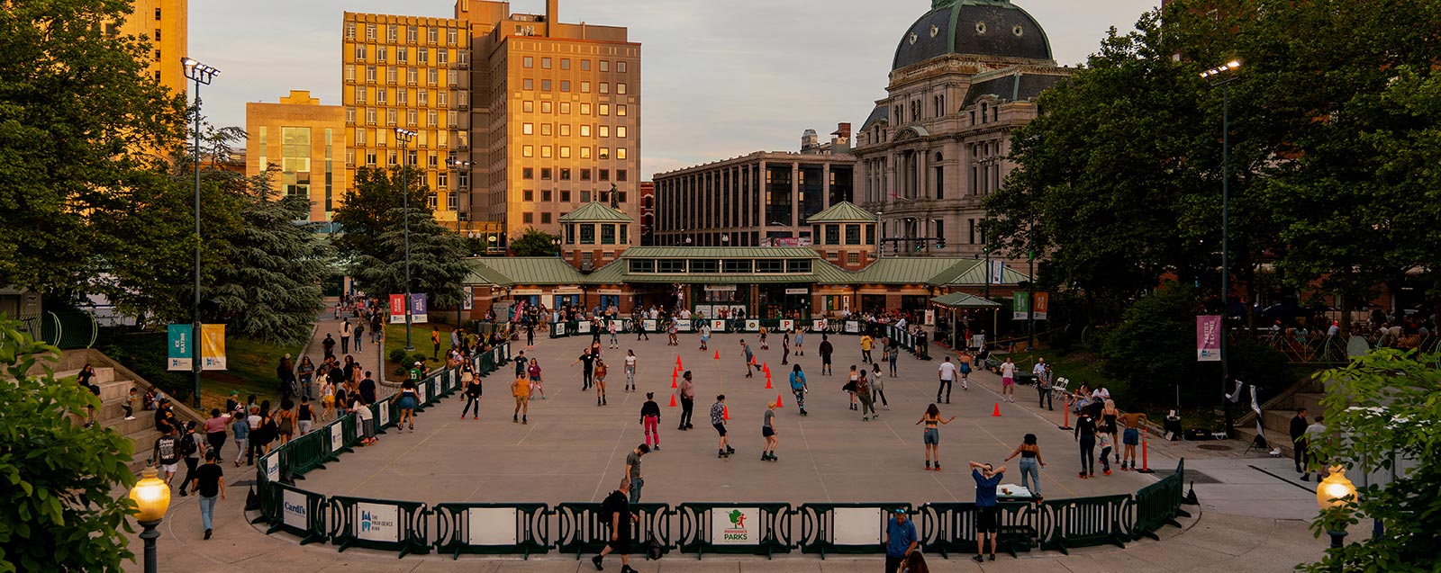 A view of the skating rink in summer with people skating on roller skates.